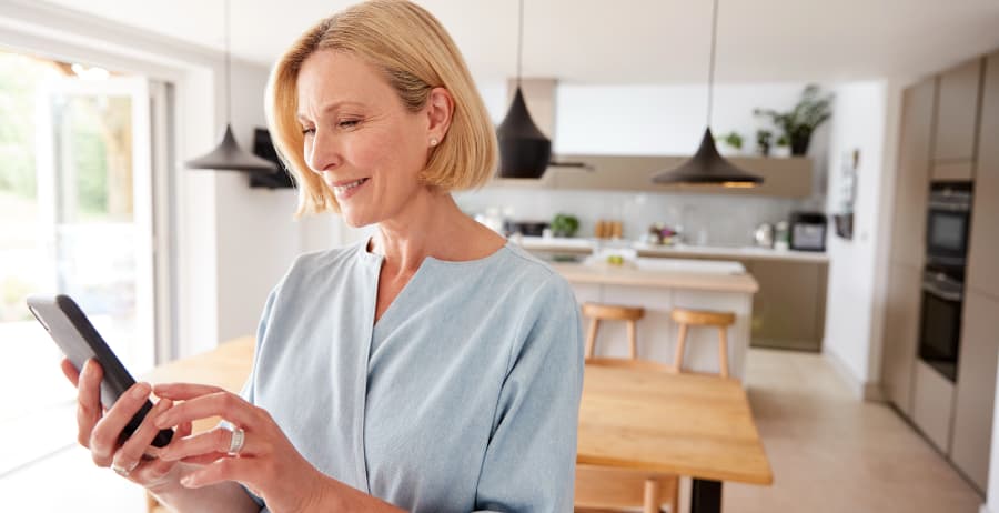 Homeowner holding a cell phone in a stylish home